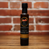 Bacon Infused Olive Oil bottle against a rustic brick backdrop.