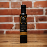 Fresh Basil Infused Olive Oil bottle against a rustic brick backdrop.