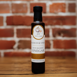 Garlic White Balsamic Vinegar bottle against a rustic brick backdrop.