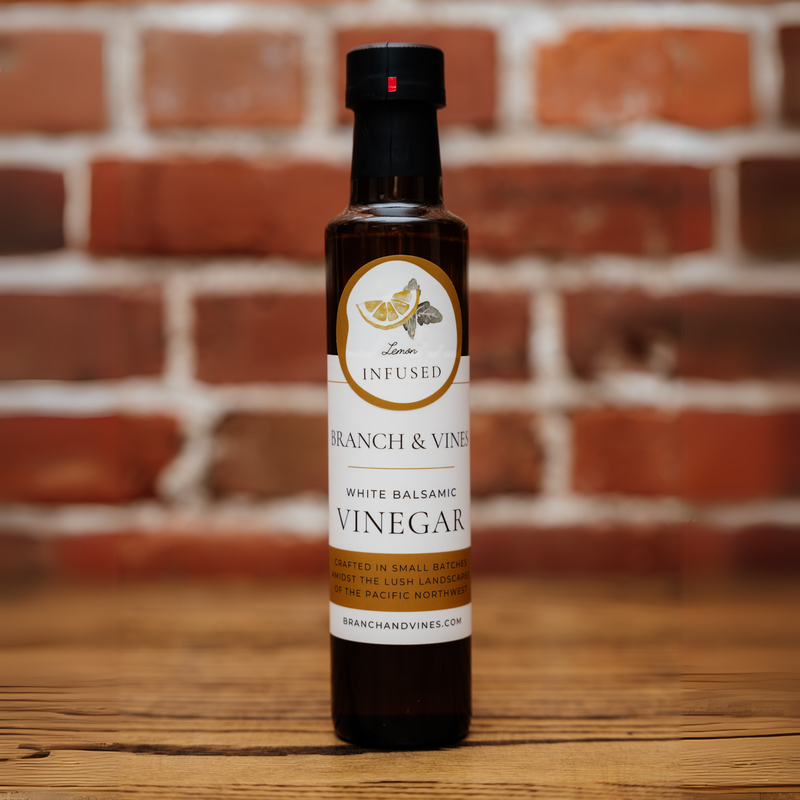 Lemon White Balsamic Vinegar bottle against a rustic brick backdrop.