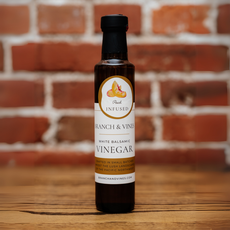 Peach White Balsamic Vinegar bottle against a rustic brick backdrop.