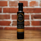 Tuscan Herb Infused Olive Oil bottle against a rustic brick backdrop.
