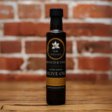 Vanilla Infused Olive Oil bottle against a rustic brick backdrop.